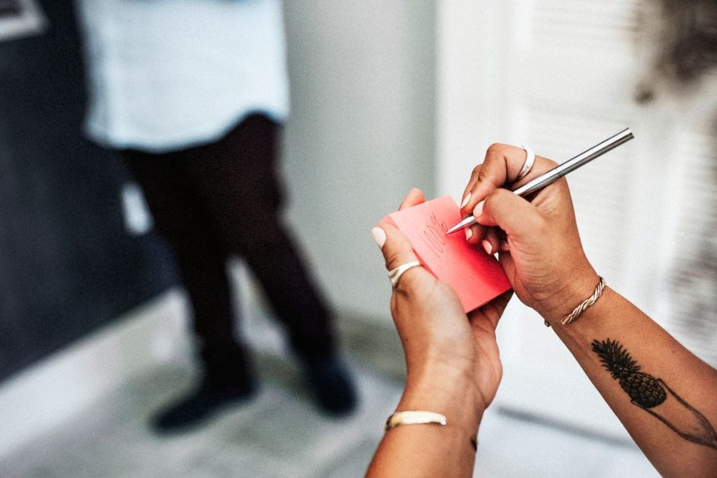 Woman writing down on an adhesive note