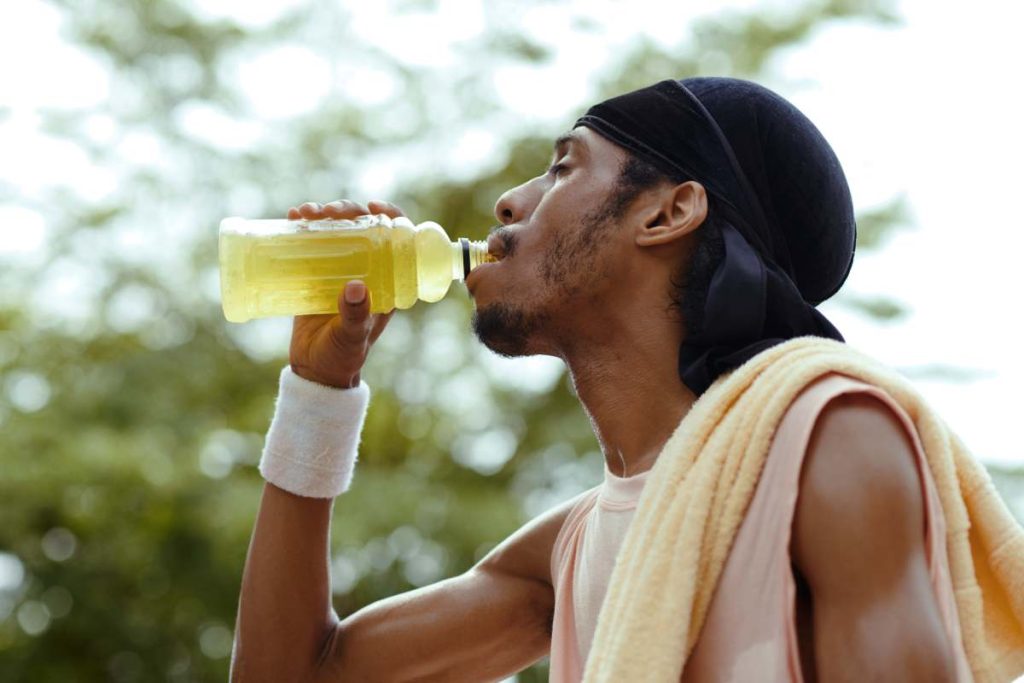 Thirsty streetball player drinking vitamin water after game of basketball