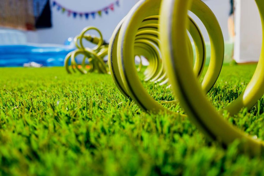 A garden on a terrace, with a hose coiled for watering.