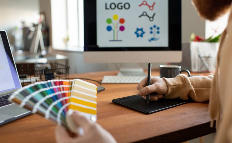 Hands of creative male freelance designer choosing colors from palette at work