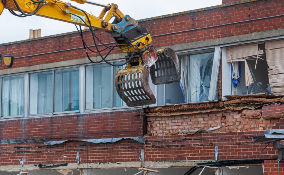 Demolition of an old building with a long reach machine hydraulic jaw. Regeneration of a space for new, modern building. Everything You Need to Know About Commercial Demolition